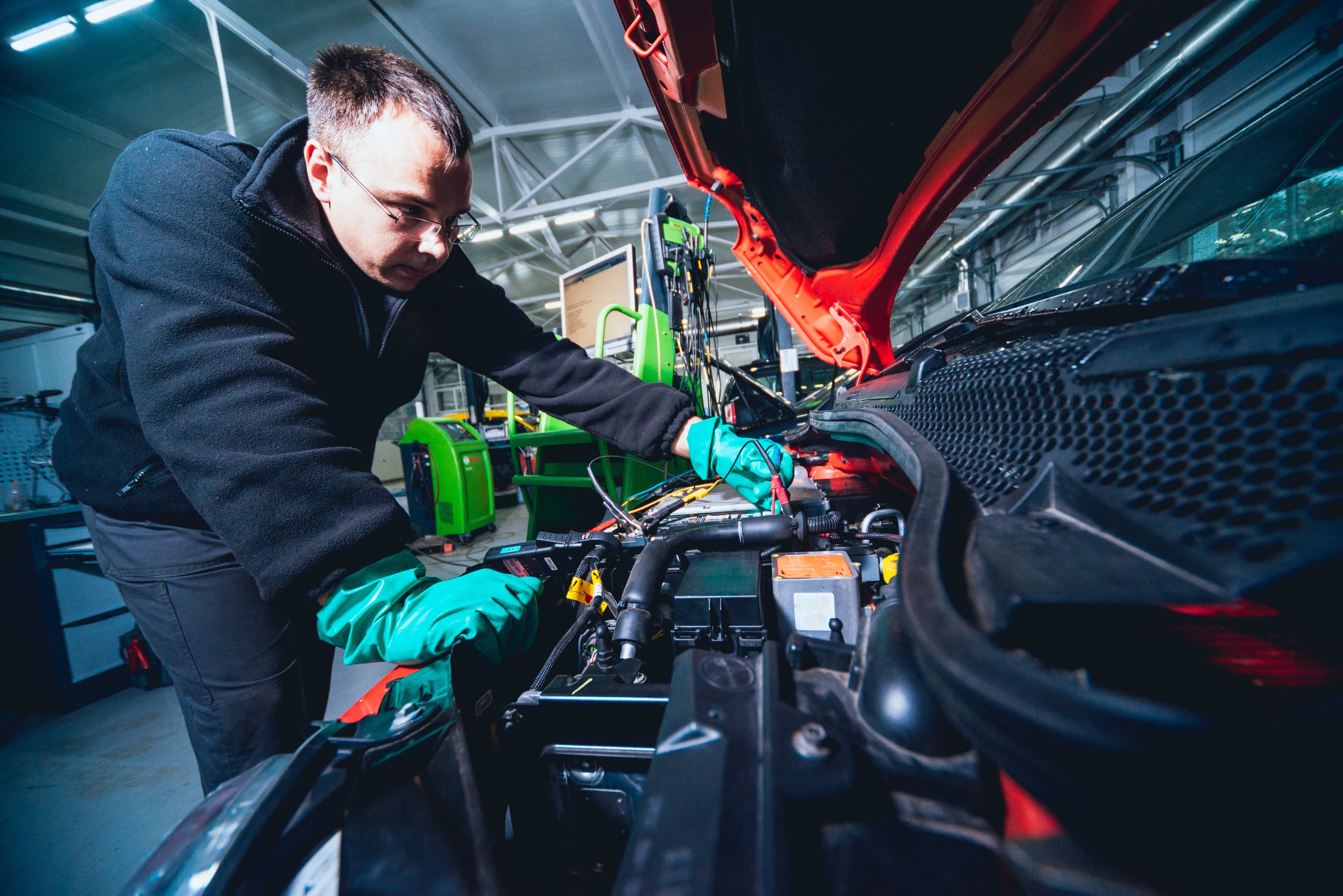 Garages struggle with training time needed for EV skills - picture shows a mechanic working on an EV engine