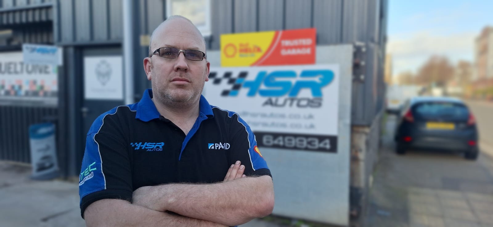 Online Bookings - Marc stood outside arms folded in front of his garage, at HSR Autos